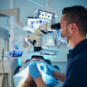 Advanced Dental Technology Used by Dentists in Los Gatos, showing a dentist using a dental microscope for precise treatment while a patient reclines in the dental chair.