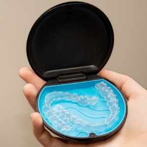 Invisalign in Los Gatos clear aligners in a protective case held in hand, discreet orthodontic treatment option.